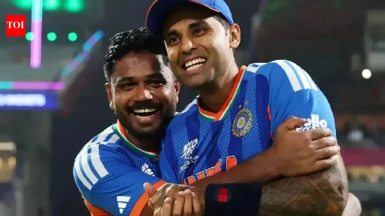 Two cricket players celebrating together on field