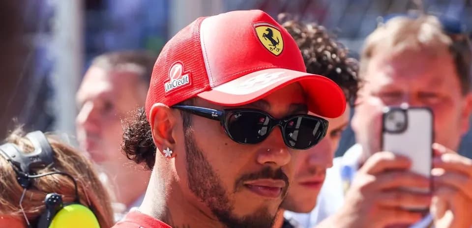 Driver wearing Ferrari cap and sunglasses in crowd