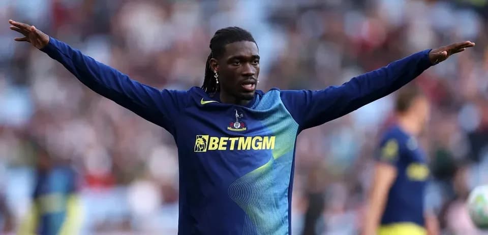 Player warming up with arms extended on pitch