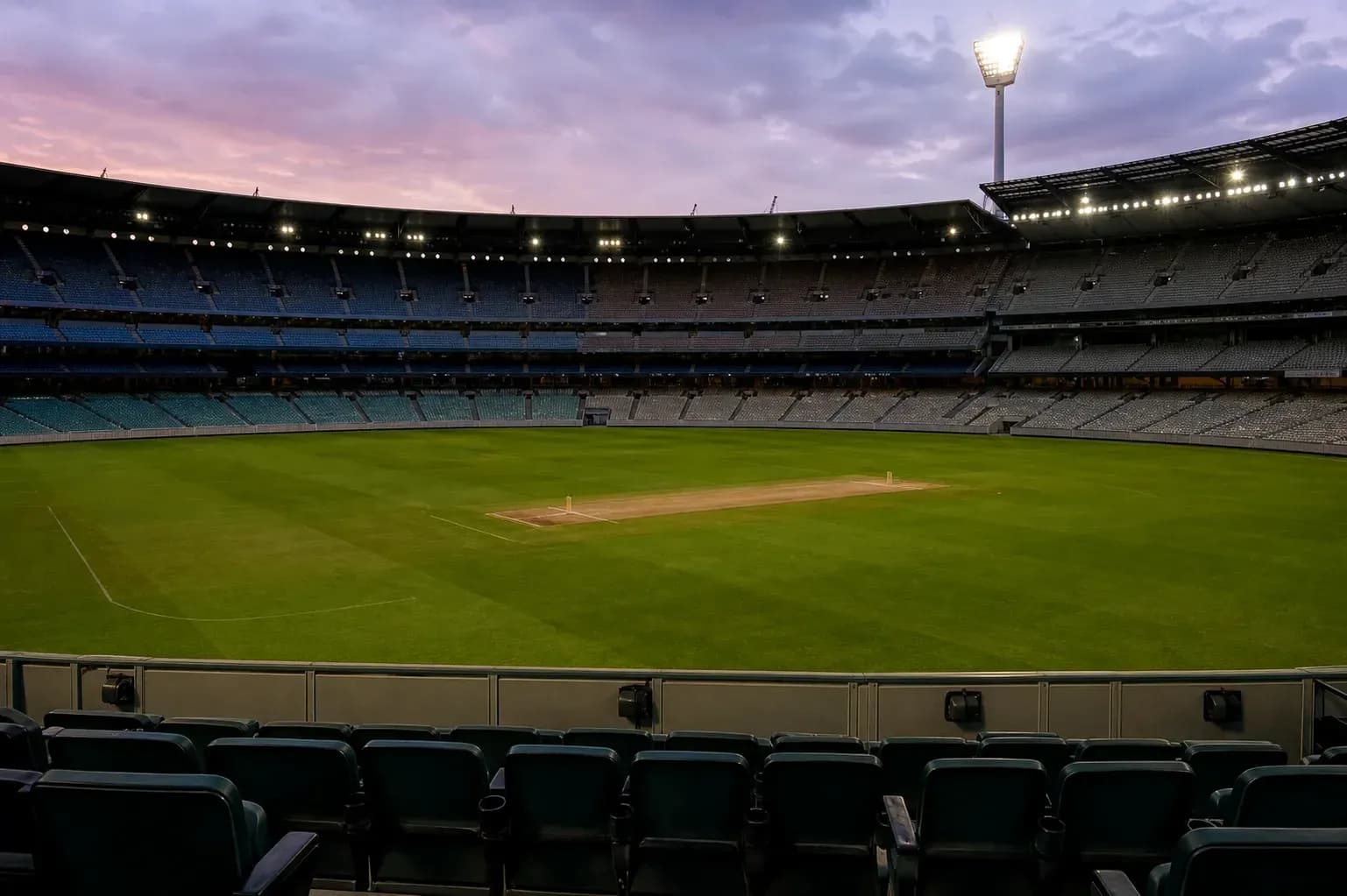 Empty cricket stadium field at dusk Empty cricket stadium field at dusk