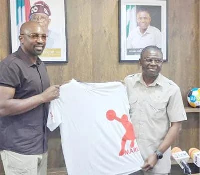 Two men holding a promotional T-shirt in an office Two men holding a promotional T-shirt in an office