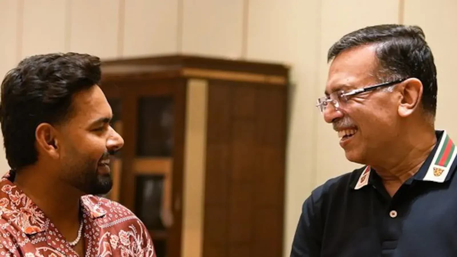 Two men smiling and talking indoors Two men smiling and talking indoors