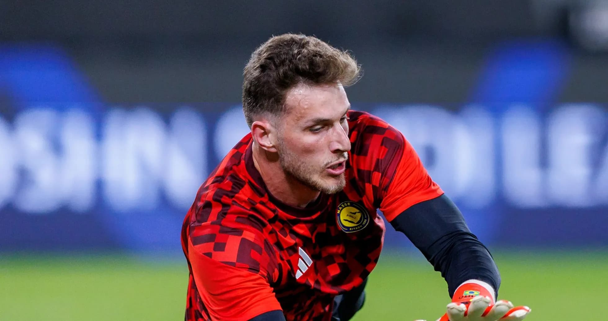 Goalkeeper in red kit making a save Goalkeeper in red kit making a save