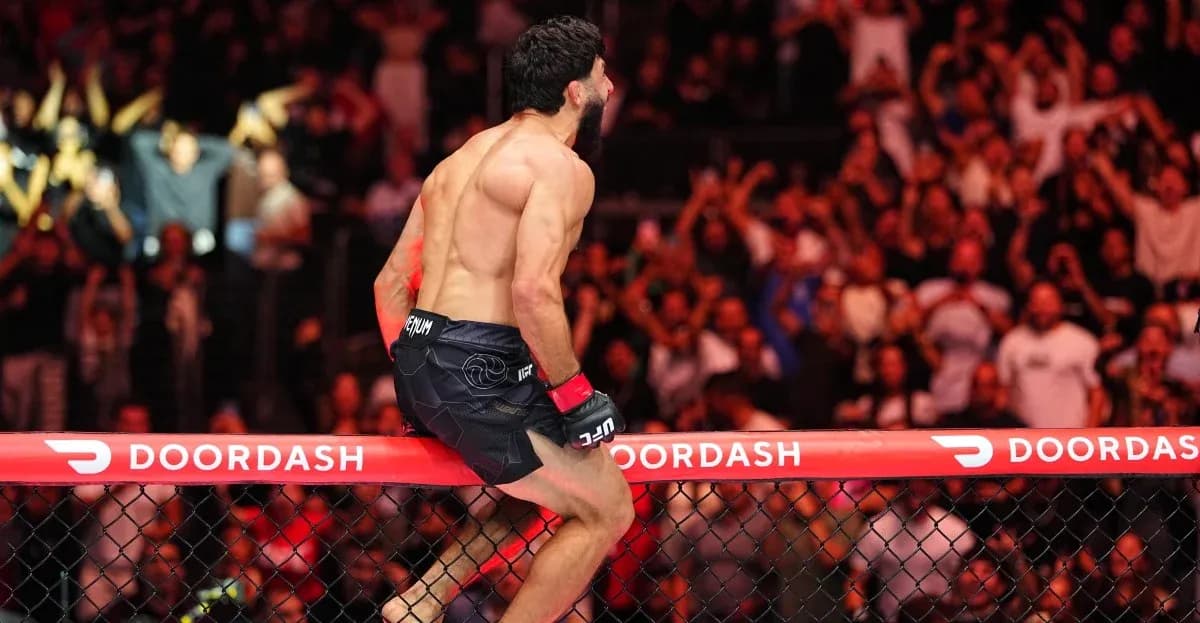 Fighter celebrating victory on the cage fence Fighter celebrating victory on the cage fence