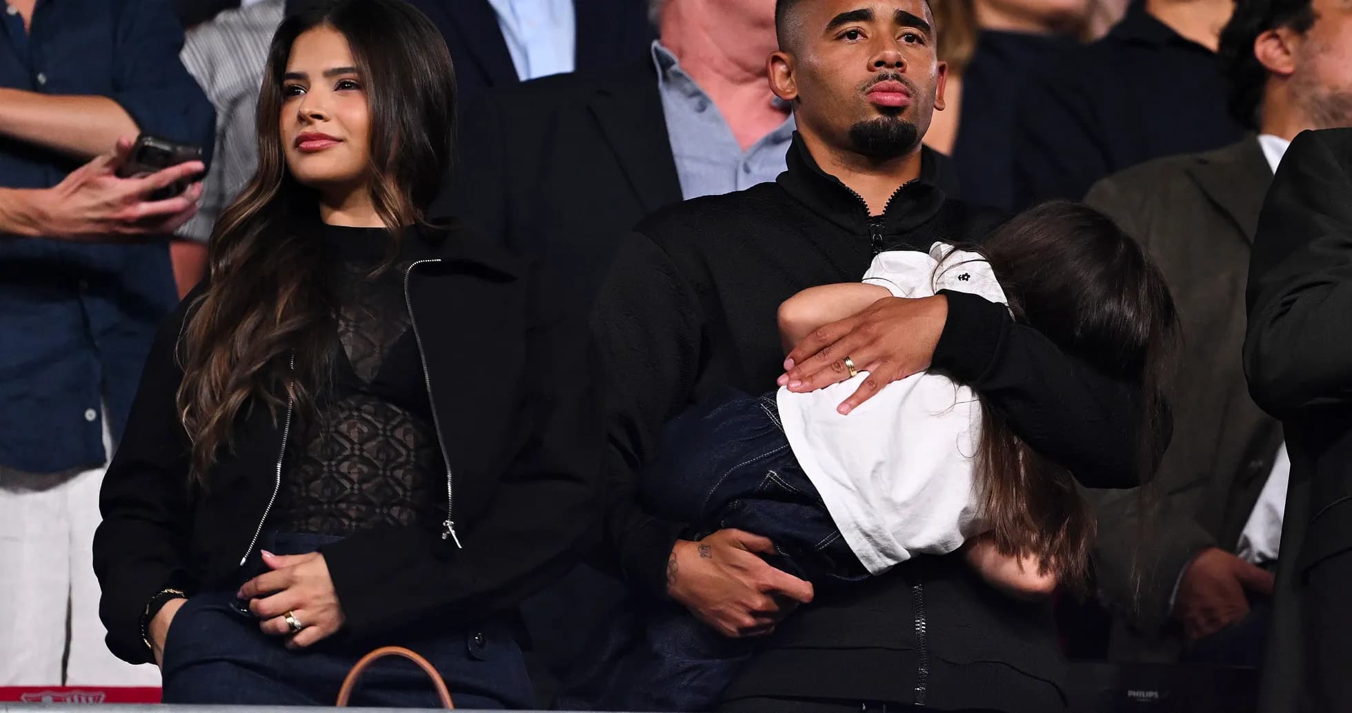Couple attending event with child in arms Couple attending event with child in arms