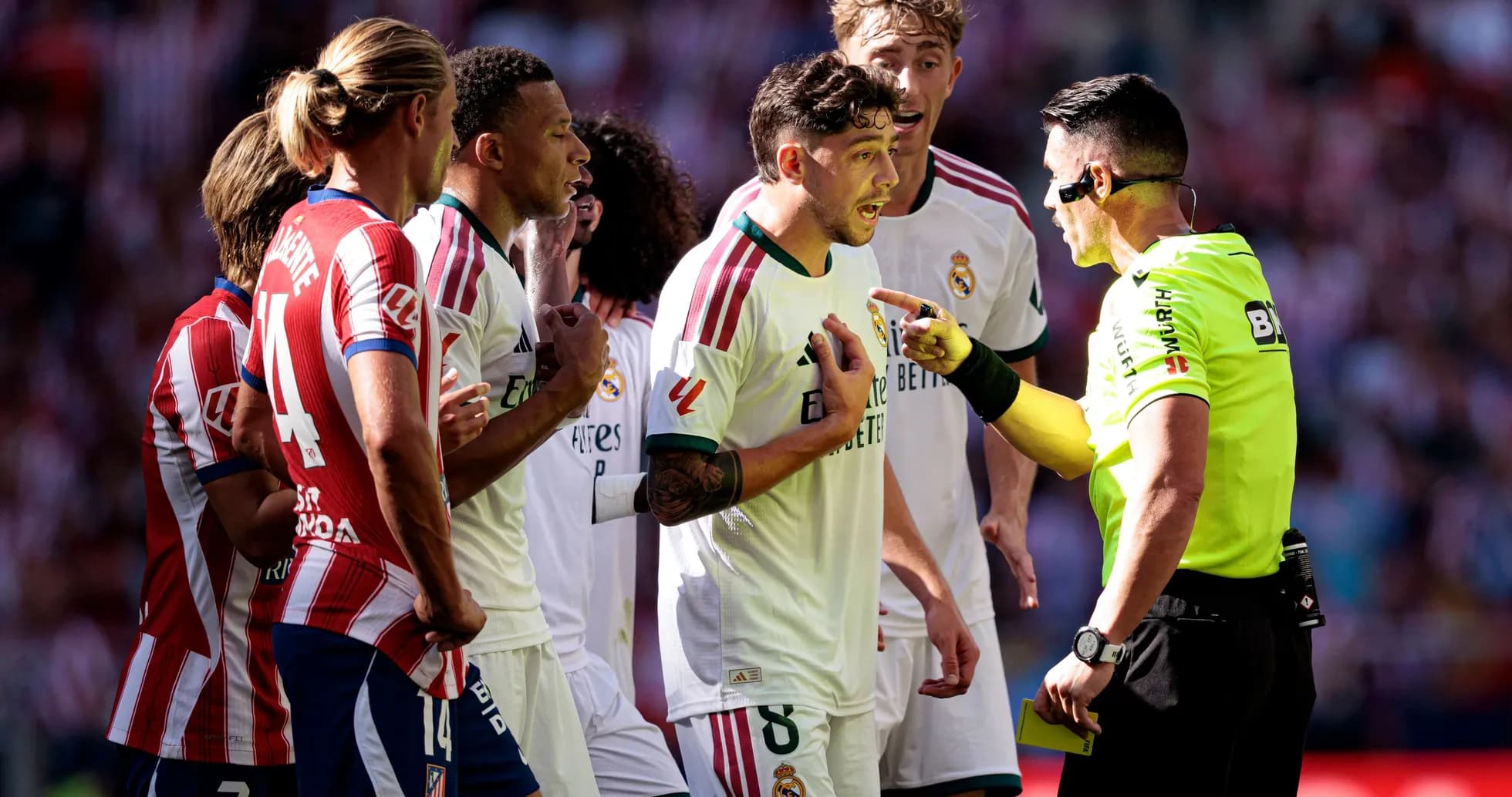 Players surrounding referee during heated match discussion Players surrounding referee during heated match discussion