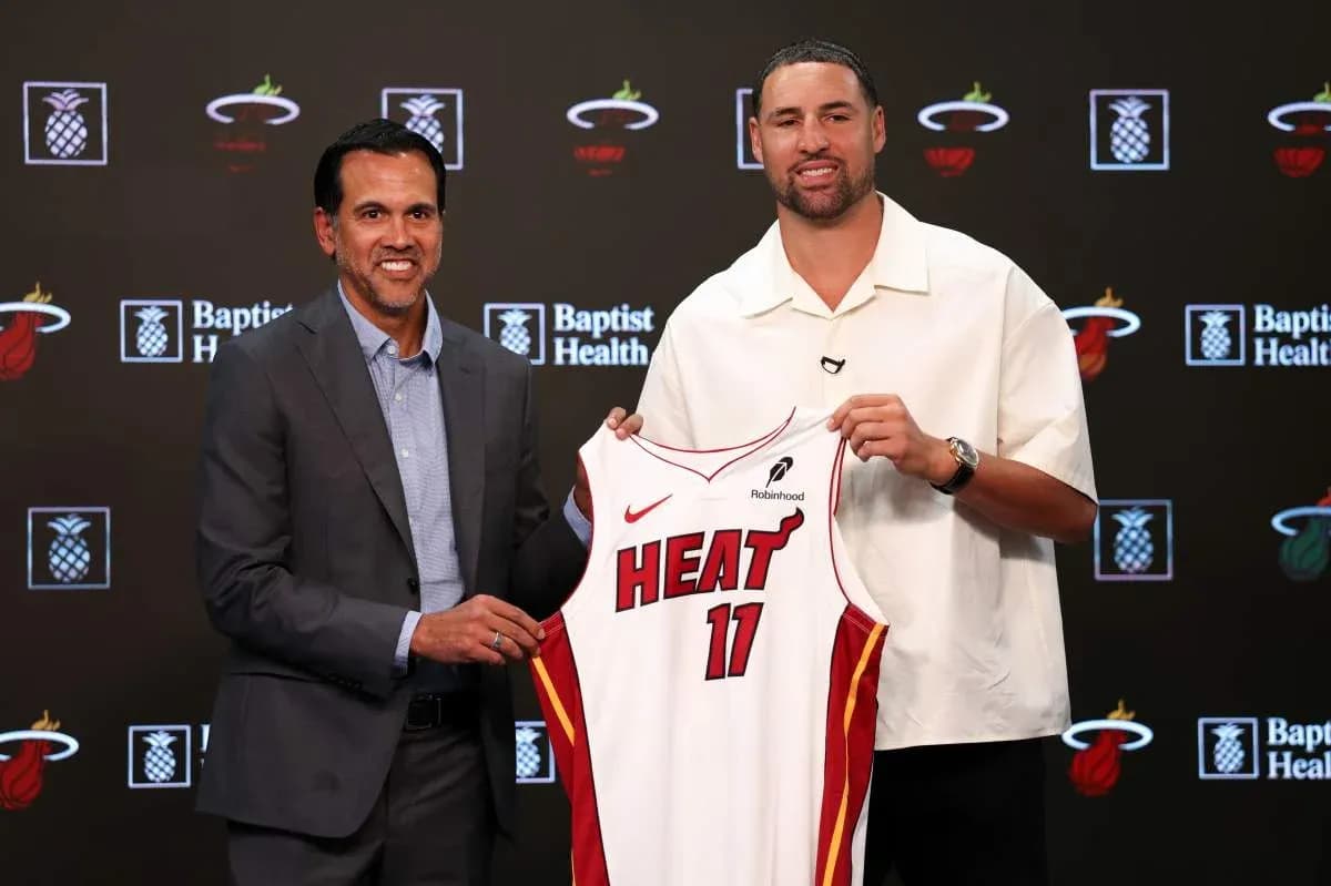 Coach and player holding Miami Heat jersey at event Coach and player holding Miami Heat jersey at event