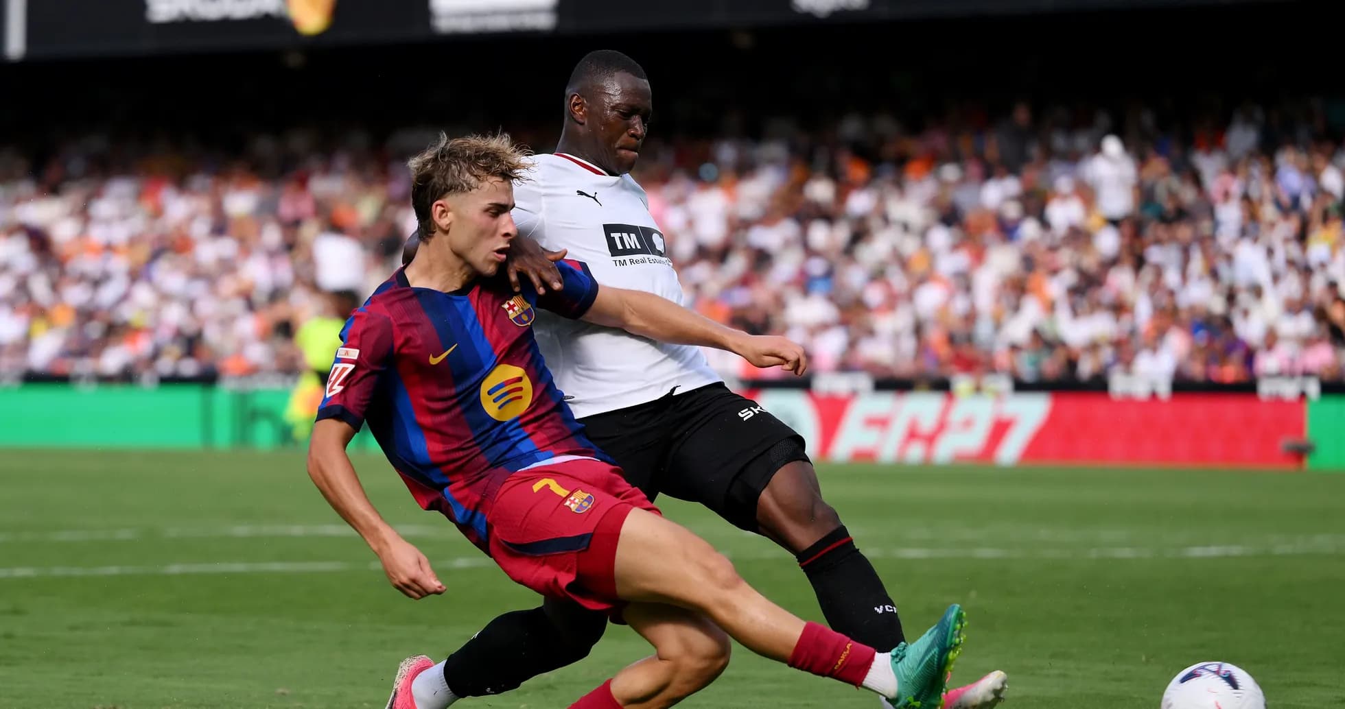 Barcelona player challenged by opposing defender during match Barcelona player challenged by opposing defender during match