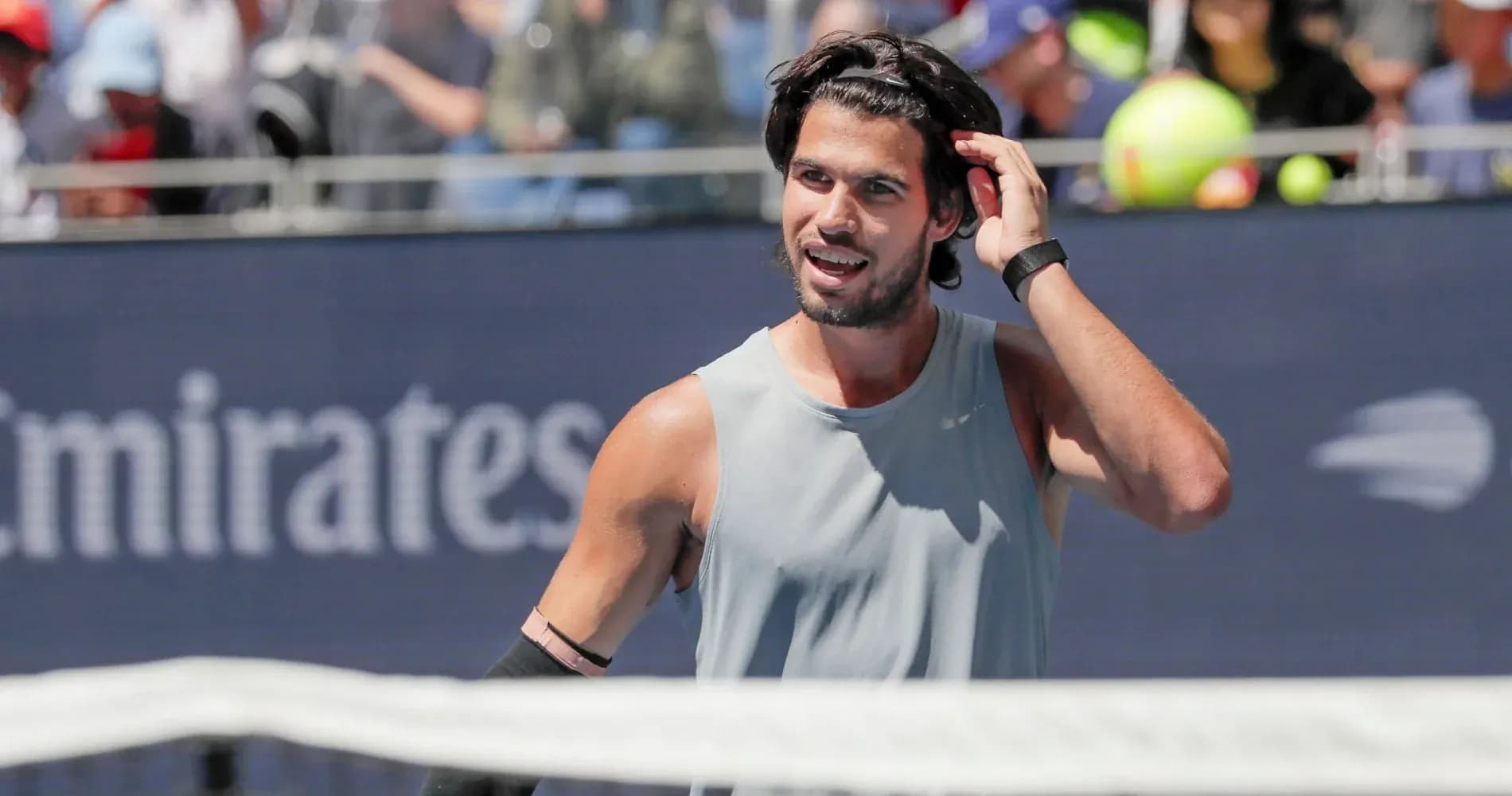 Tennis player adjusting hair during match on court Tennis player adjusting hair during match on court