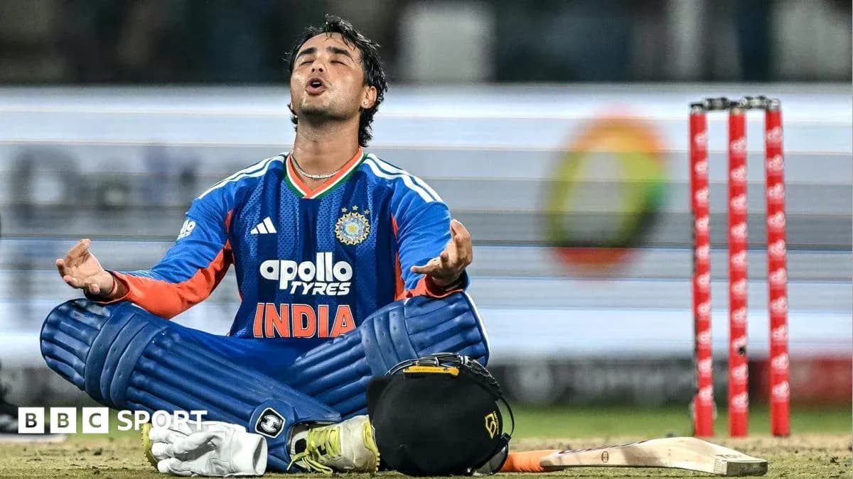 Cricketer seated on field, arms raised in prayer Cricketer seated on field, arms raised in prayer