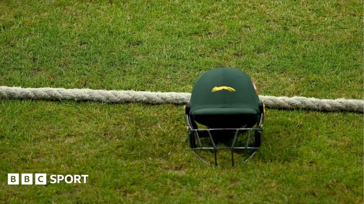 Cricket helmet resting on grass near boundary rope Cricket helmet resting on grass near boundary rope