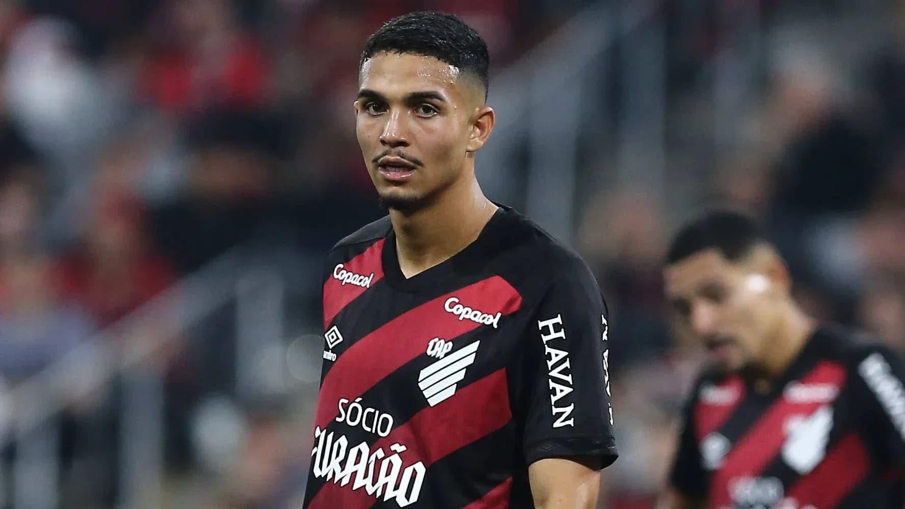 Player wearing red and black jersey on field Player wearing red and black jersey on field