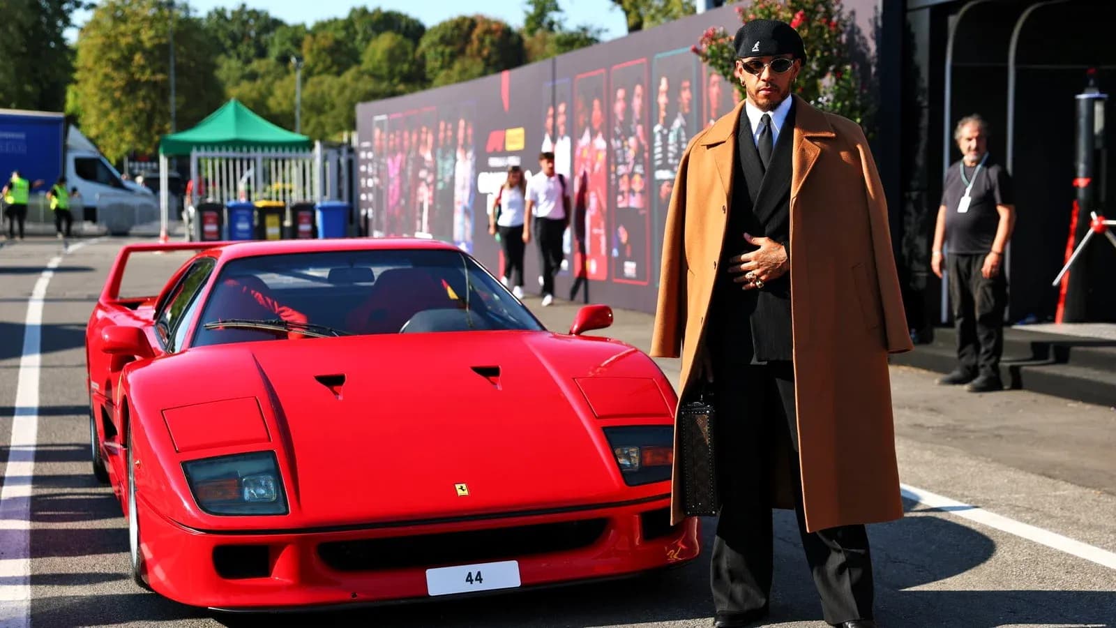 Person in stylish outfit next to red Ferrari F40 Person in stylish outfit next to red Ferrari F40