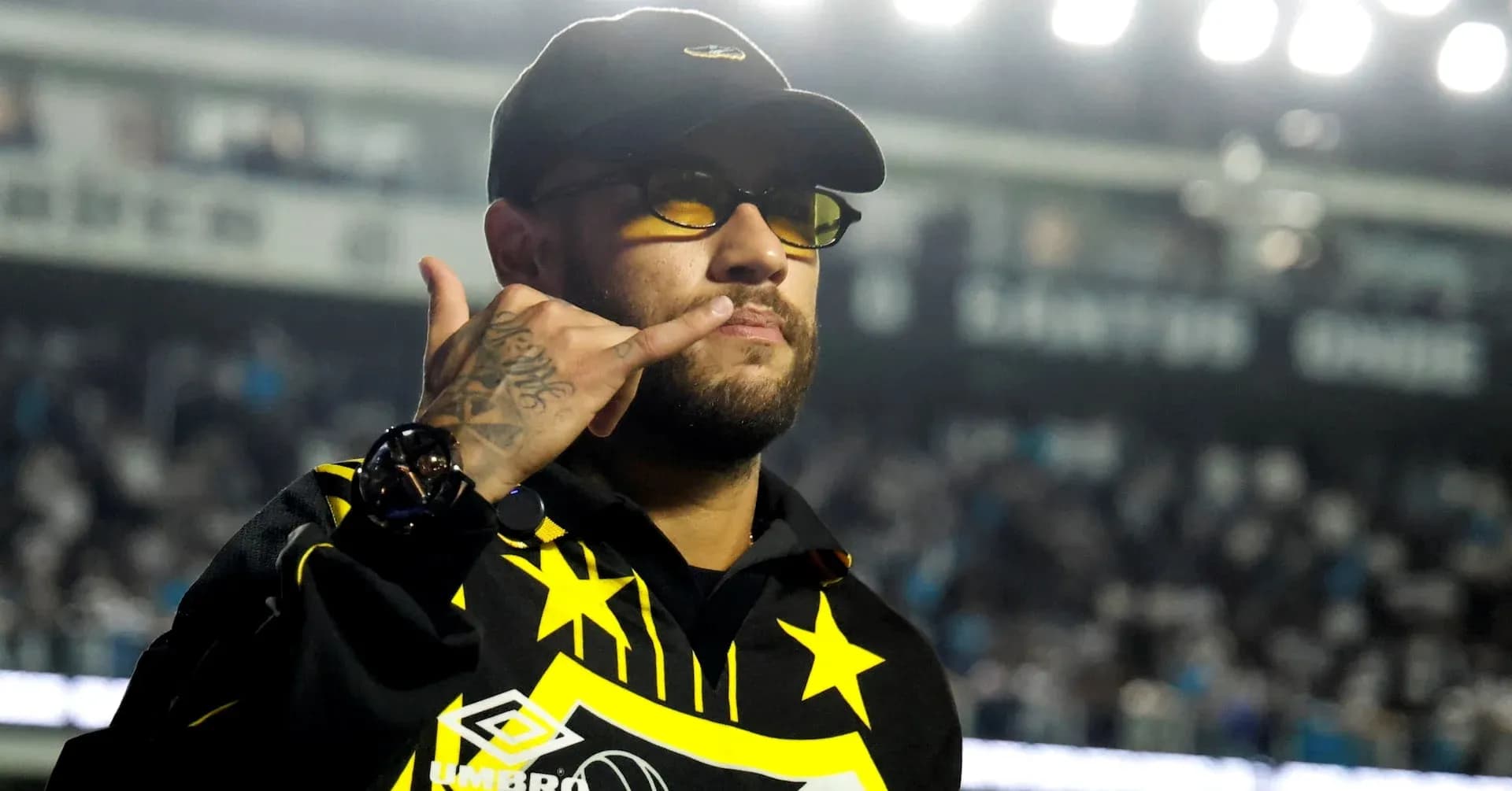 Person making a hand gesture in a stadium Person making a hand gesture in a stadium