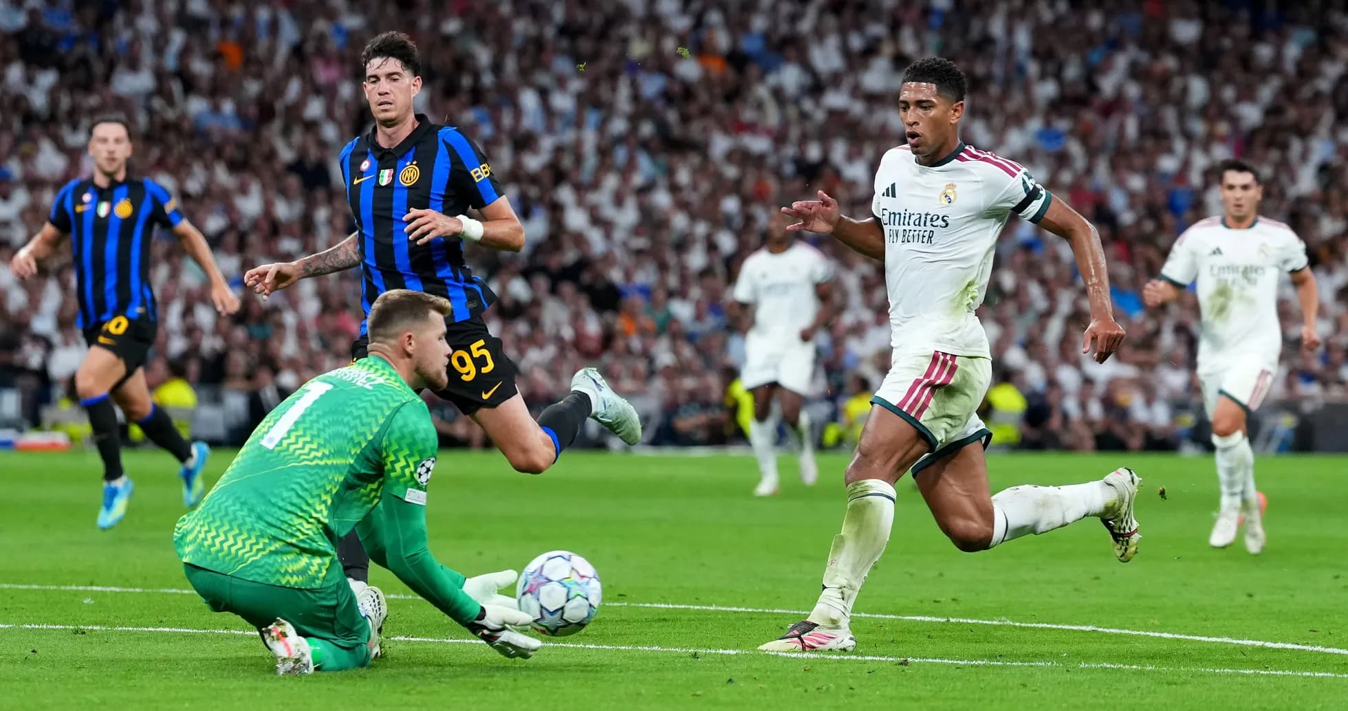 Real Madrid player sprinting past goalkeeper during match Real Madrid player sprinting past goalkeeper during match