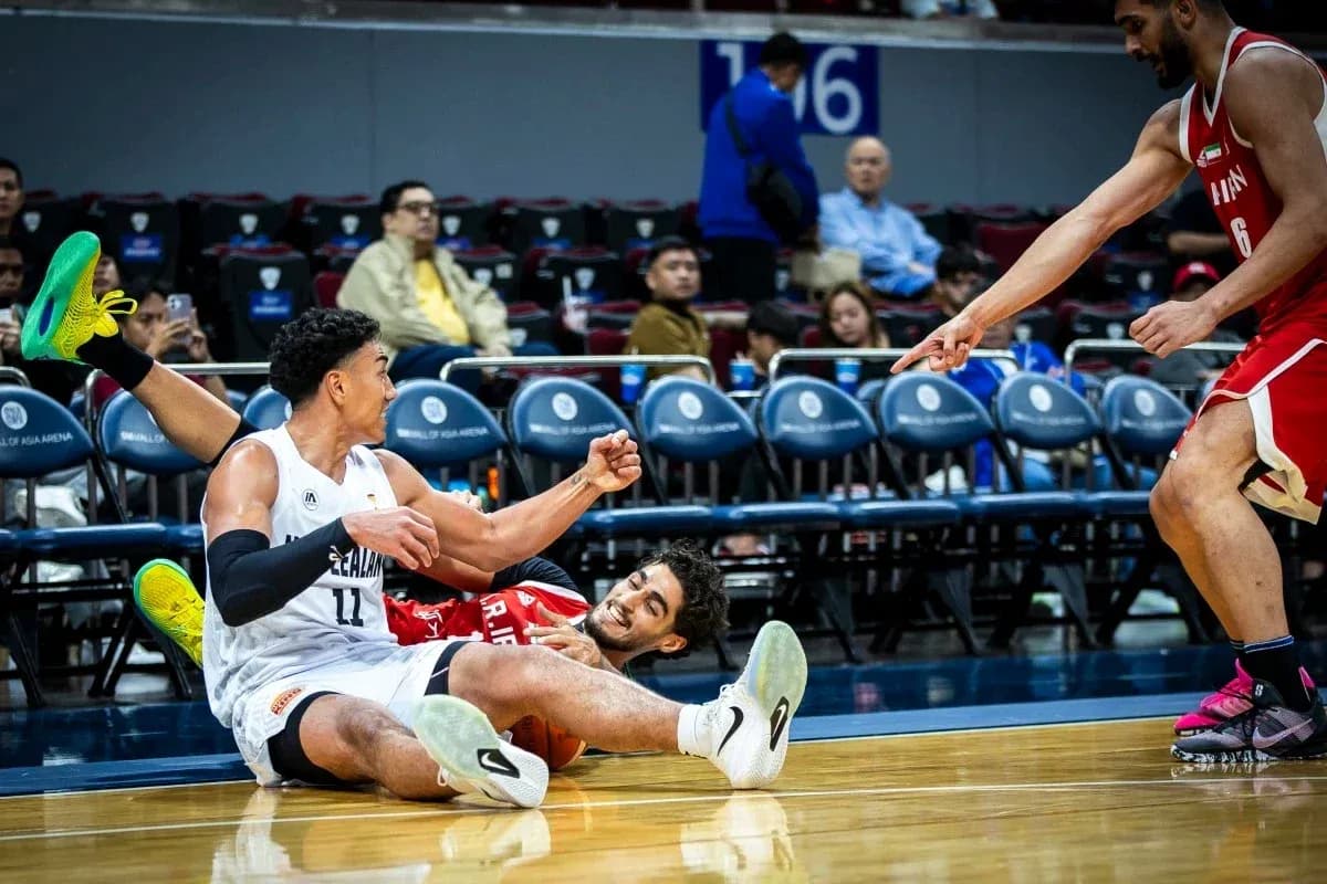 Players on the floor competing for the basketball Players on the floor competing for the basketball
