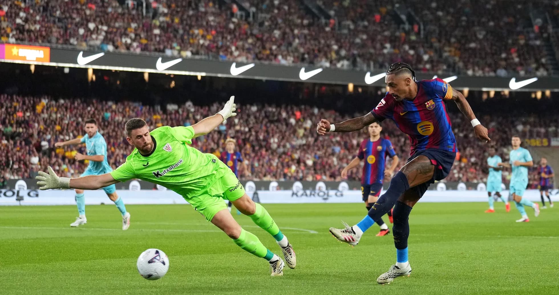 Barcelona player shoots as goalkeeper attempts to save Barcelona player shoots as goalkeeper attempts to save