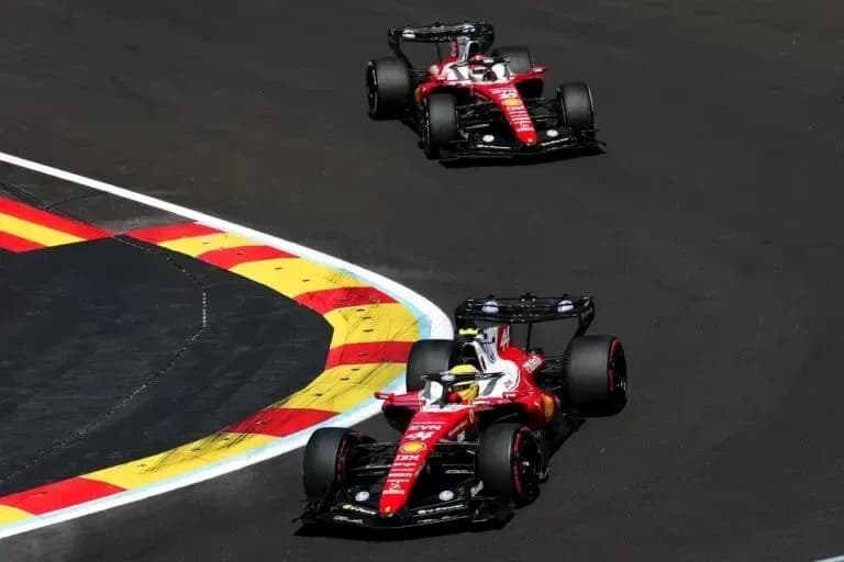 Two Ferrari cars navigating a corner on track Two Ferrari cars navigating a corner on track