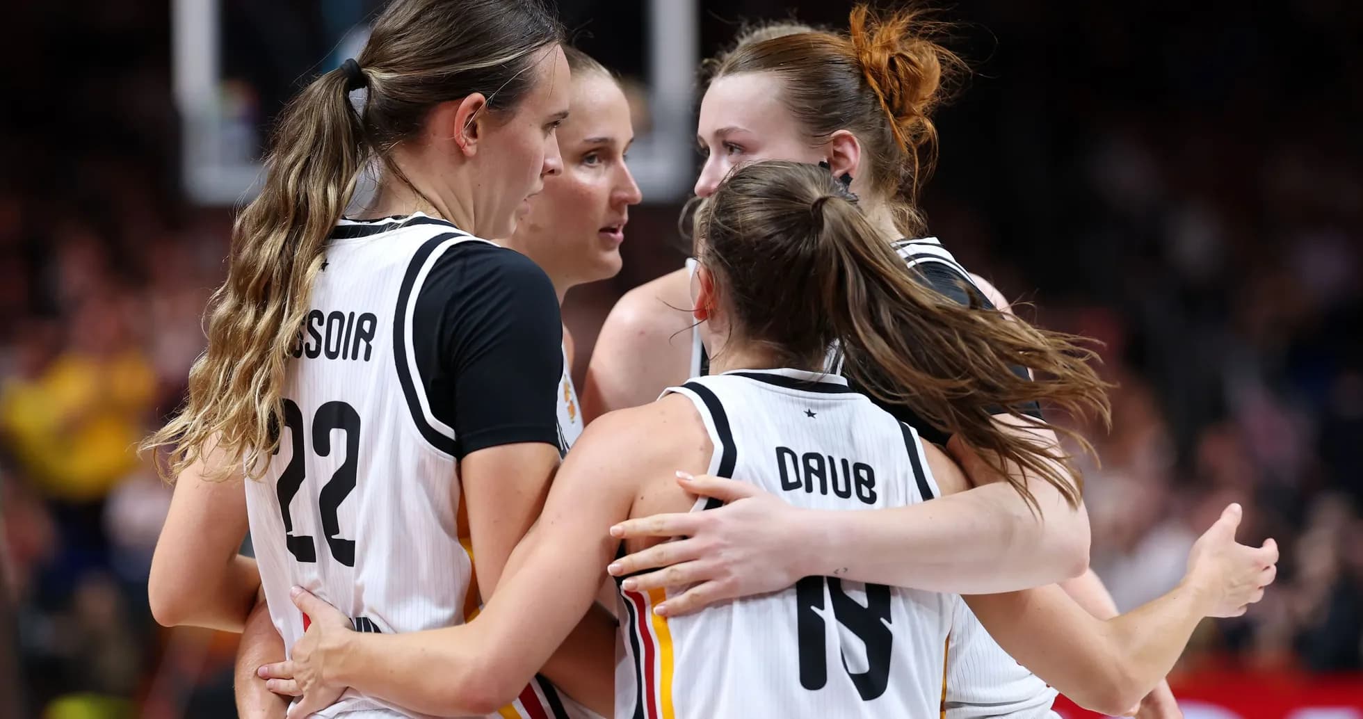 Four basketball players celebrating together on court Four basketball players celebrating together on court
