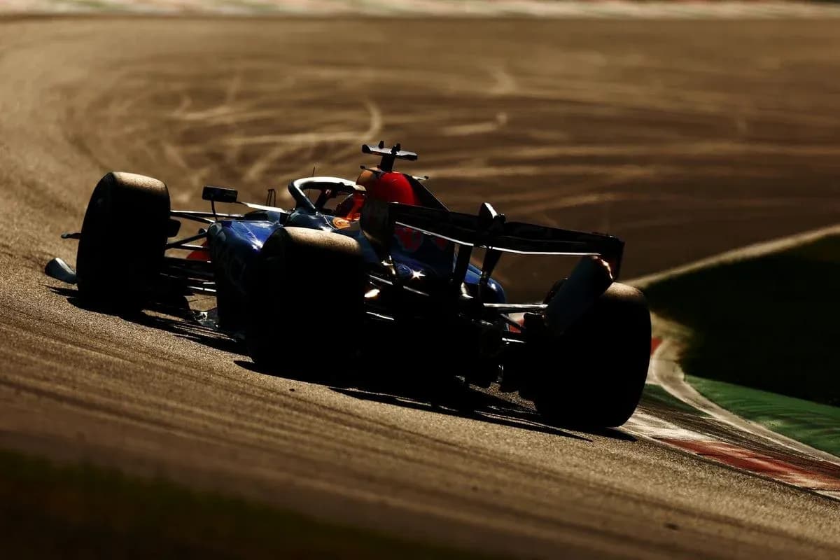 Formula 1 car driving on track during sunset Formula 1 car driving on track during sunset