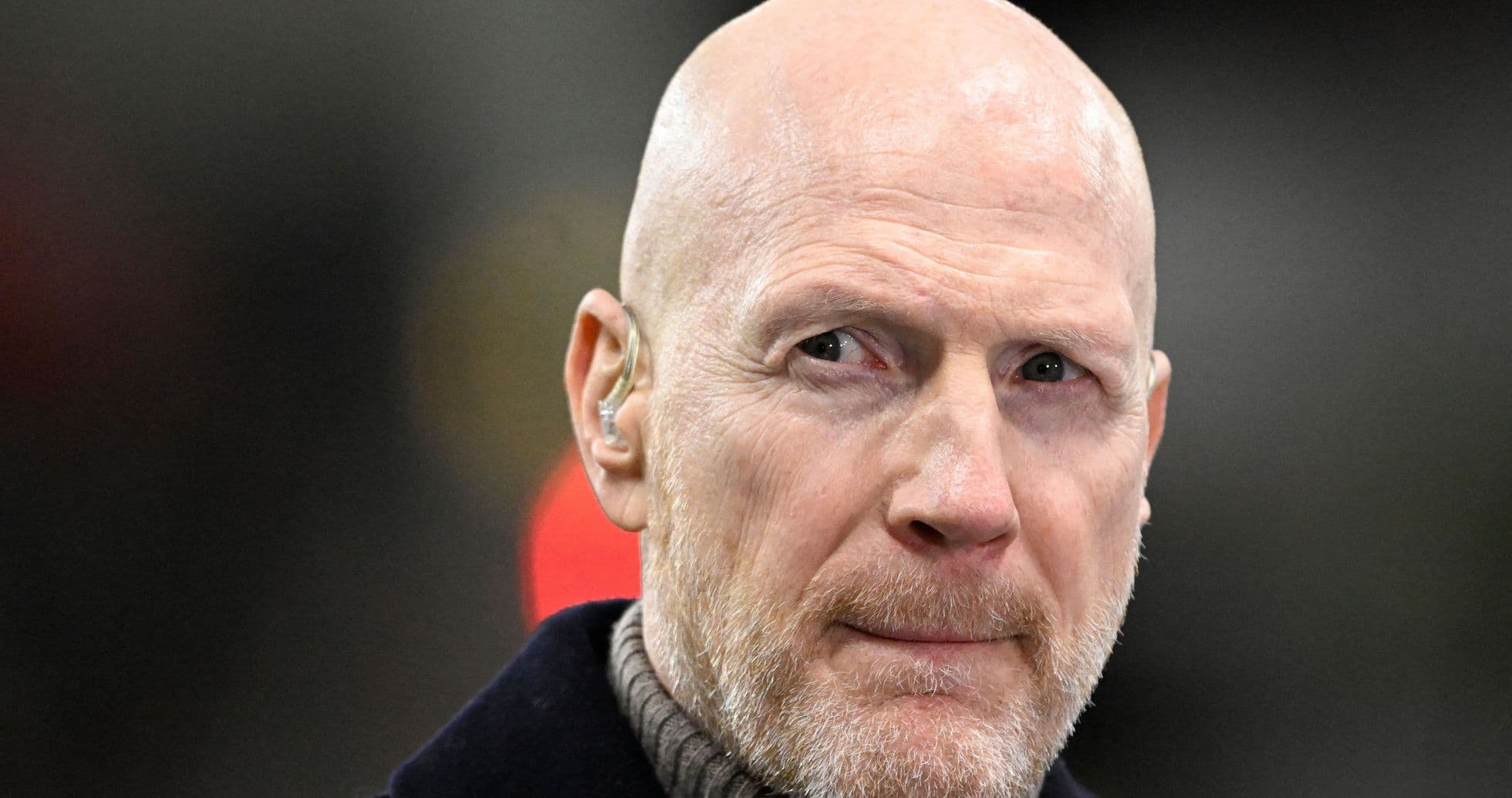 Bald man with earpiece looking intently Bald man with earpiece looking intently