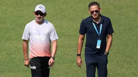 Two men walking on a grass field Two men walking on a grass field