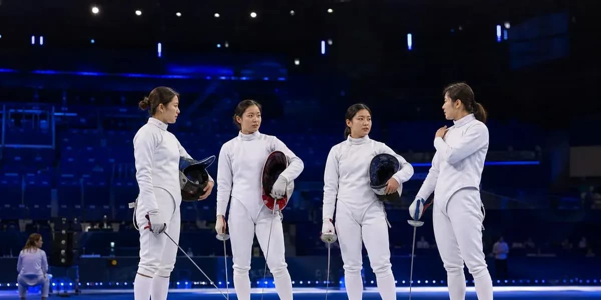 Four fencers discussing strategies on the piste Four fencers discussing strategies on the piste