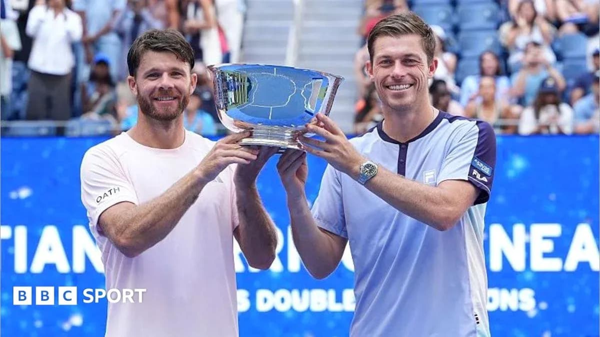Two tennis players holding a trophy together Two tennis players holding a trophy together