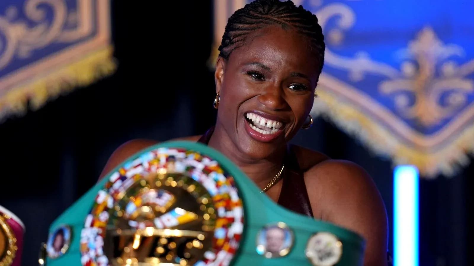 Female boxer holding championship belts and smiling Female boxer holding championship belts and smiling