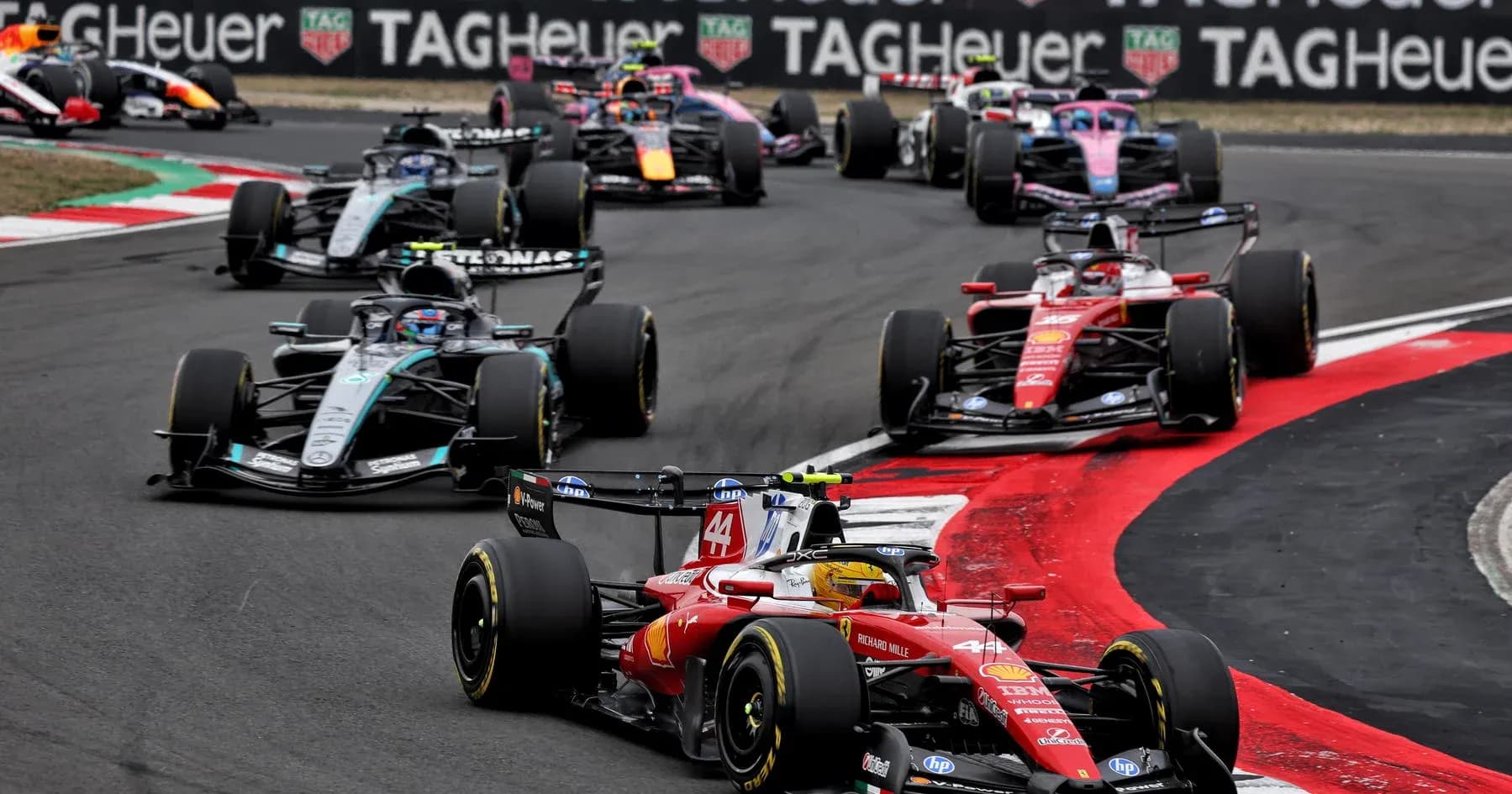 Formula 1 cars racing on a track during competition Formula 1 cars racing on a track during competition