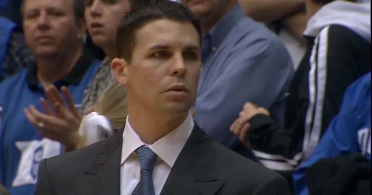 Coach observing game with fans in background Coach observing game with fans in background