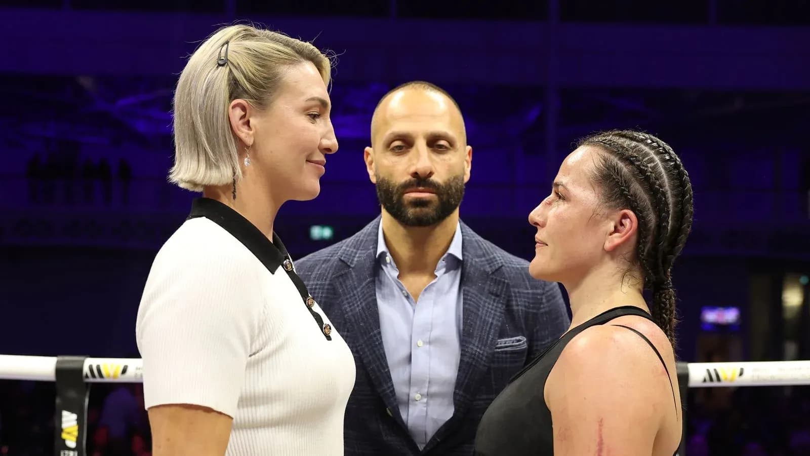 Two fighters facing off before a match with a referee Two fighters facing off before a match with a referee