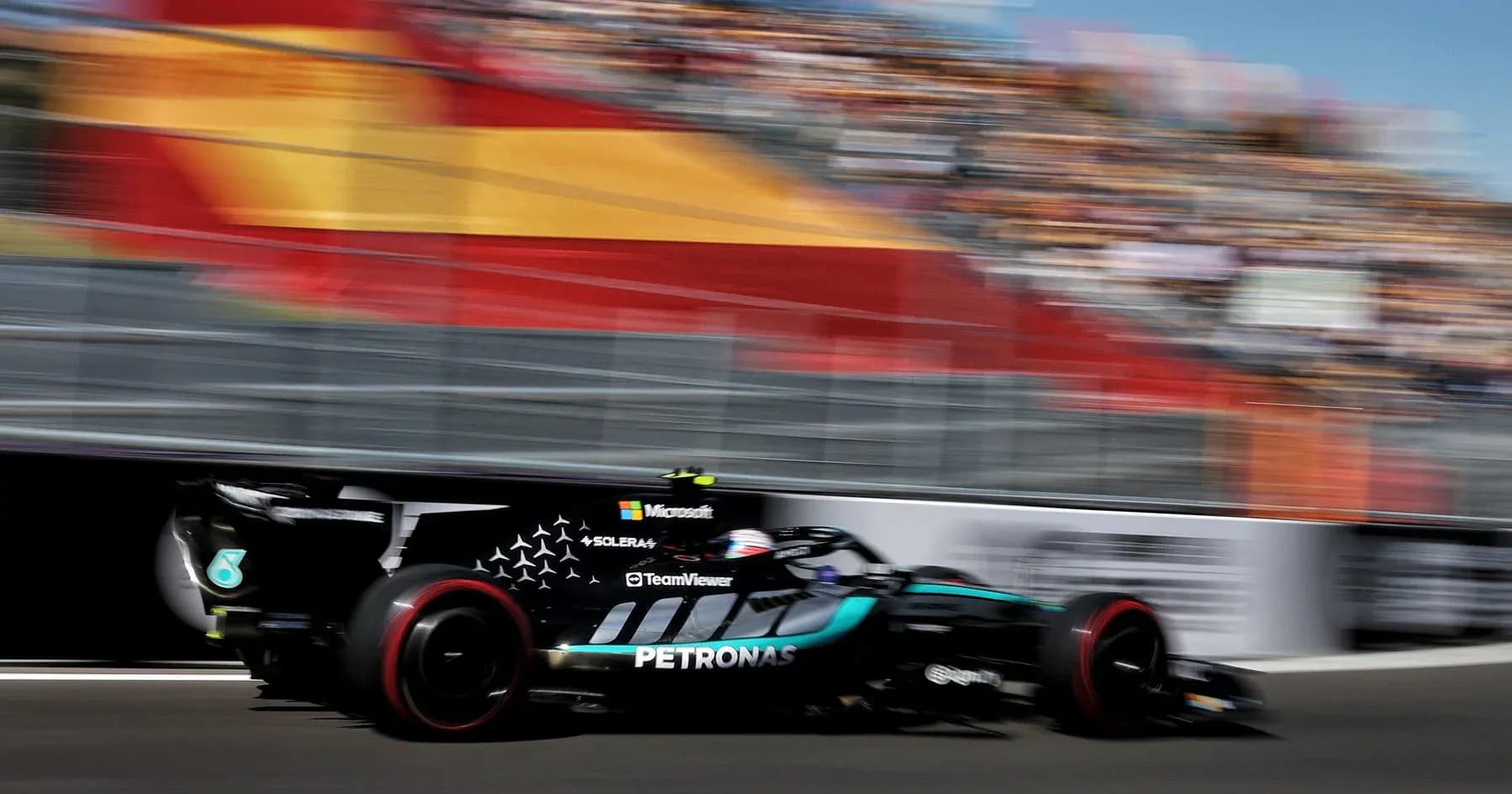 Formula 1 car racing past crowd at event Formula 1 car racing past crowd at event