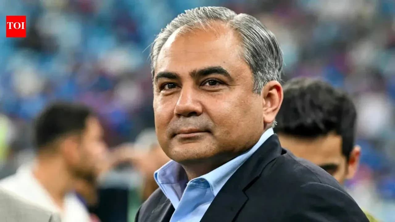 Person in suit at sports event with crowd behind Person in suit at sports event with crowd behind