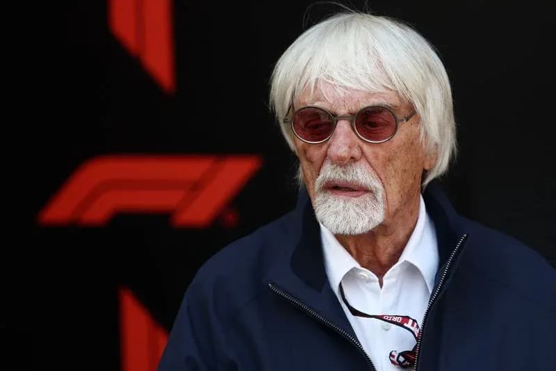 Man with white hair and glasses near F1 logo Man with white hair and glasses near F1 logo