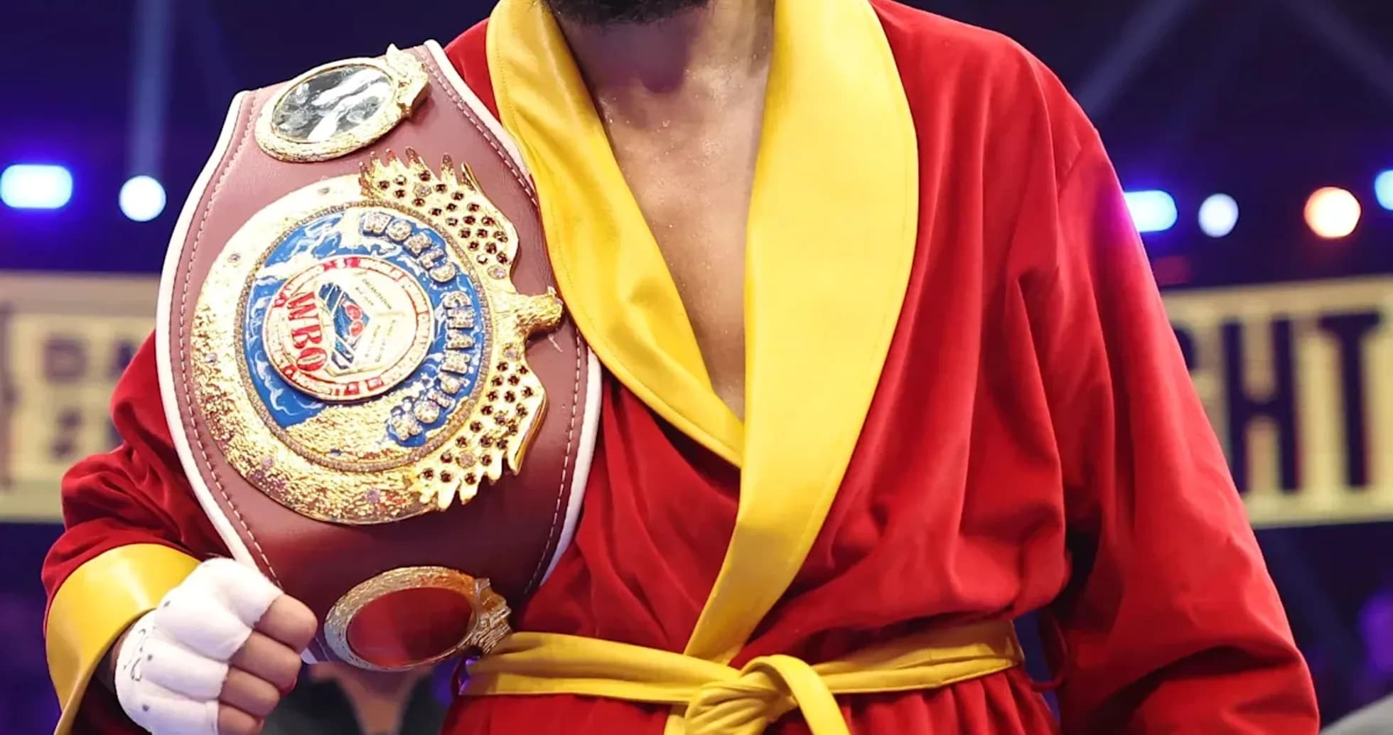 Boxer in red robe holding championship belt Boxer in red robe holding championship belt