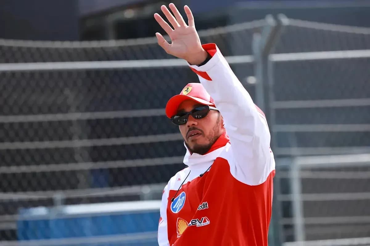 Driver waving while wearing racing team uniform Driver waving while wearing racing team uniform