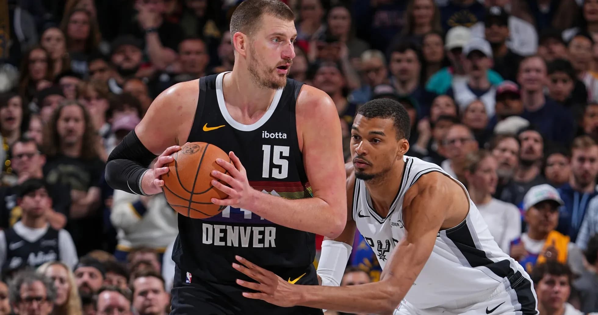 Nikola Jokić dribbling while defended by opponent Nikola Jokić dribbling while defended by opponent