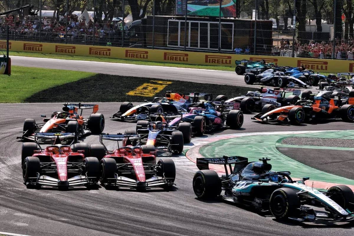 Multiple Formula 1 cars racing around a corner Multiple Formula 1 cars racing around a corner