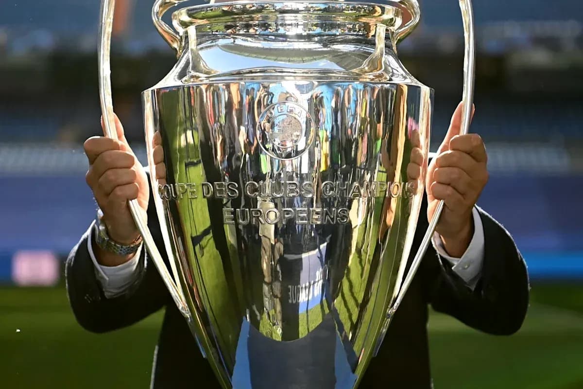 Person holding UEFA Champions League trophy Person holding UEFA Champions League trophy