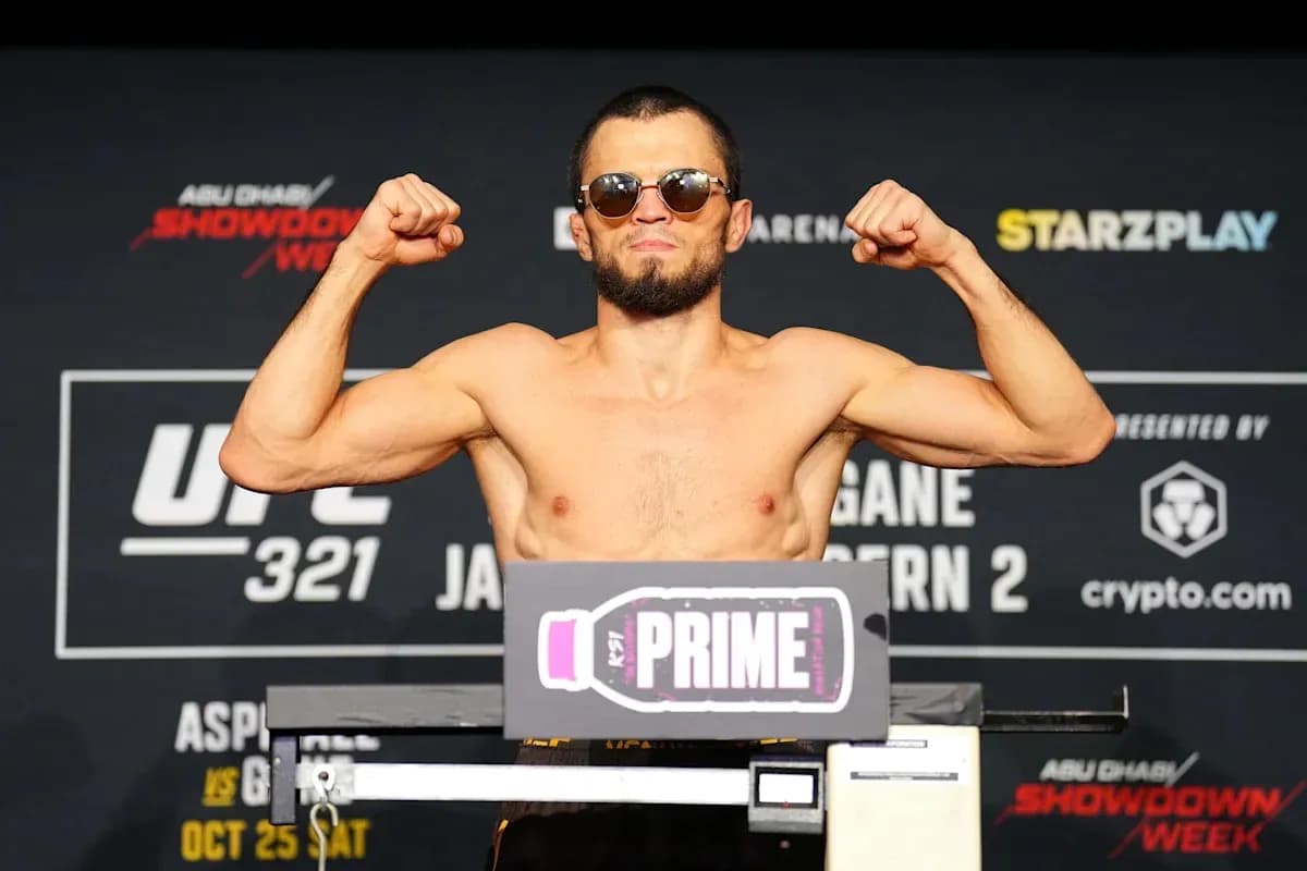 Fighter posing on scale at UFC 321 weigh-in Fighter posing on scale at UFC 321 weigh-in