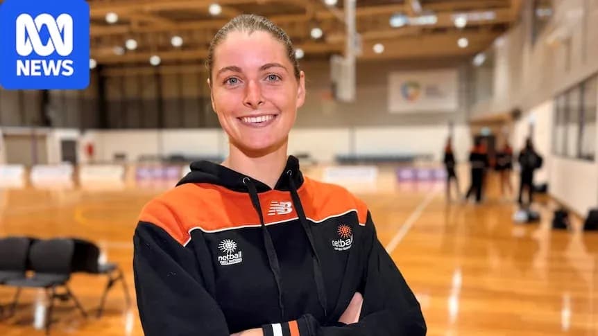Netball player smiling in training venue Netball player smiling in training venue