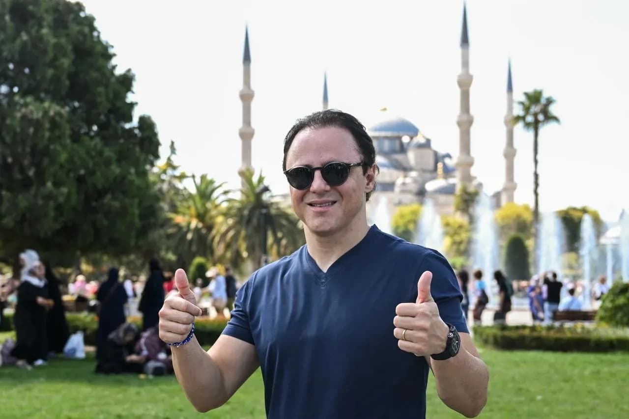 Man giving thumbs up in front of mosque Man giving thumbs up in front of mosque