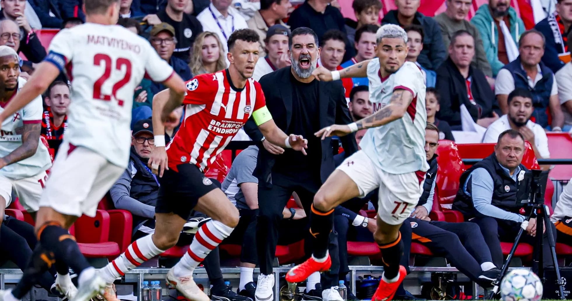 Players competing during a football match with coach reacting Players competing during a football match with coach reacting